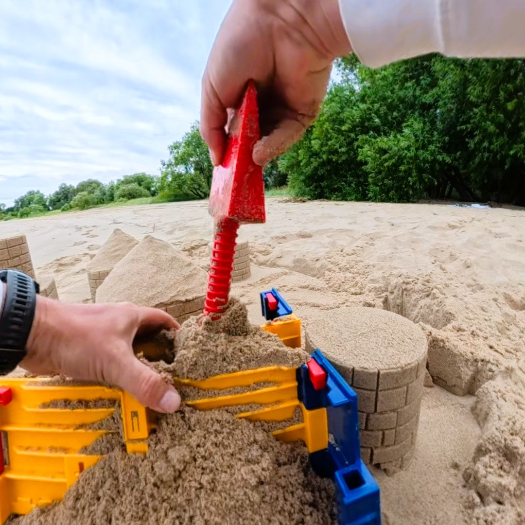 Sandmasons Sandcastle Kit Shovel packing sand firmly into a sandcastle form before lifting it away.