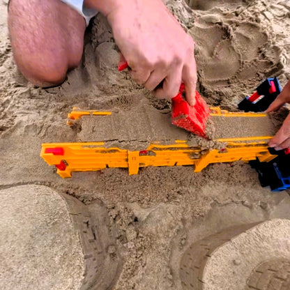 Sandmasons Sandcastle Kit Shovel scraping sand from the top of a sandcastle form for a smooth finish.